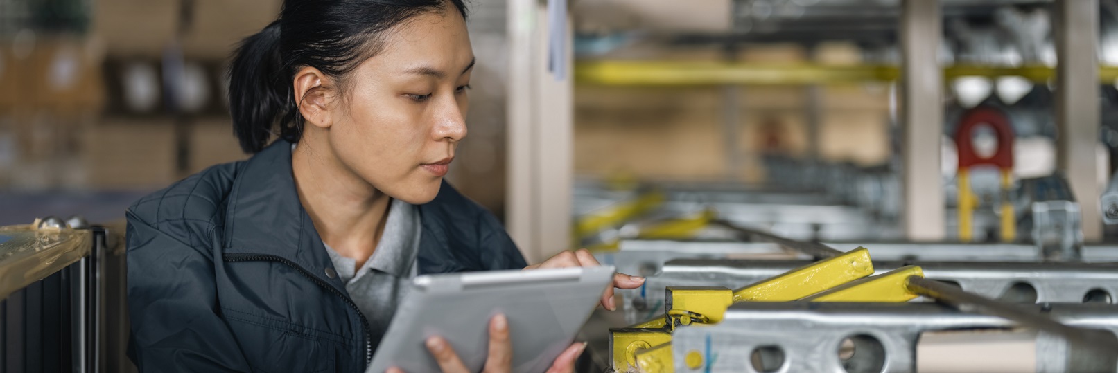 Female worker in warehouse on tablet.